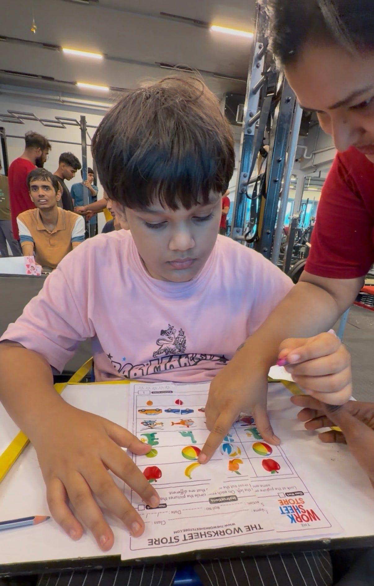 A coach guiding a young child through a learning activity