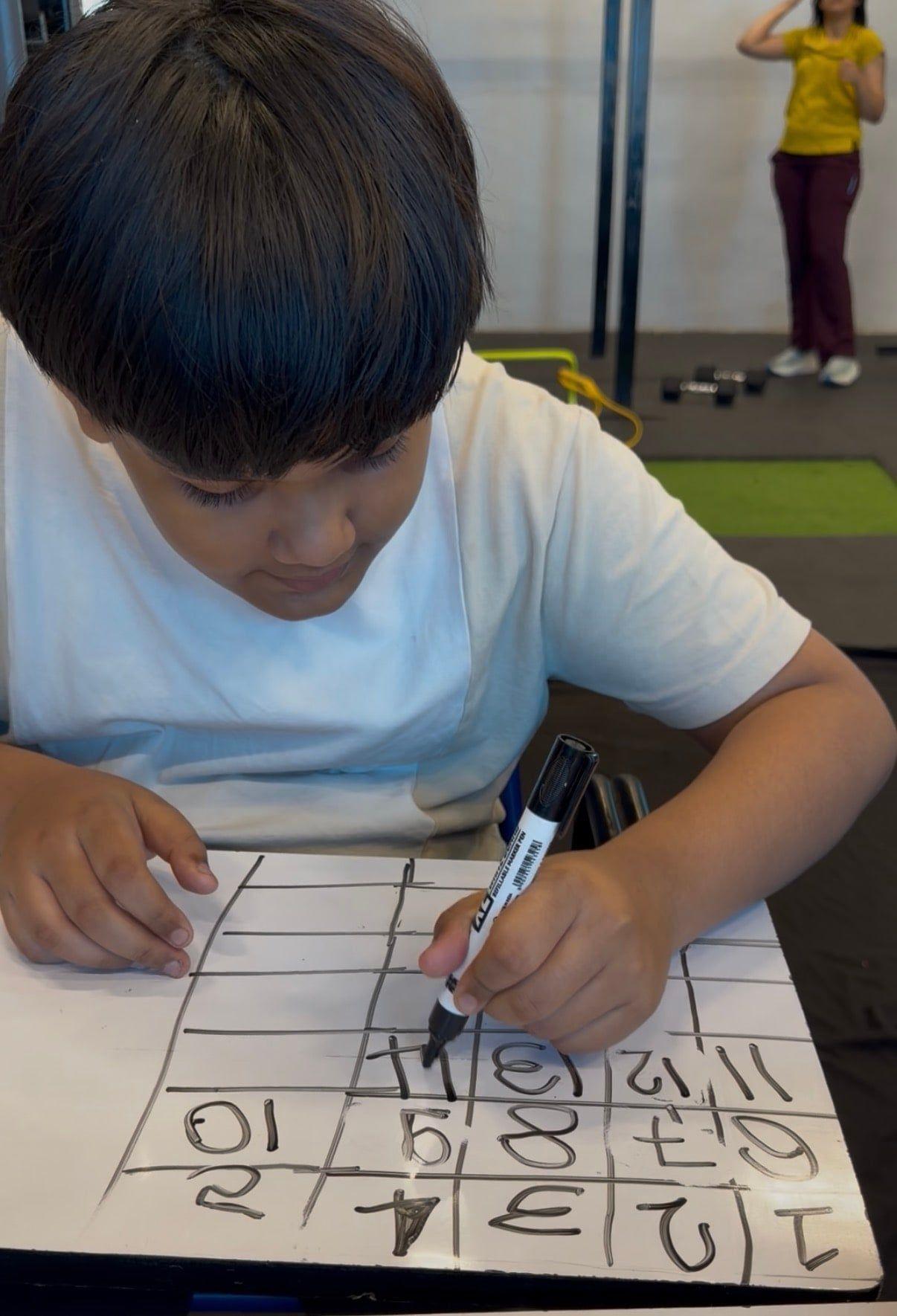 A child writing numbers on a worksheet