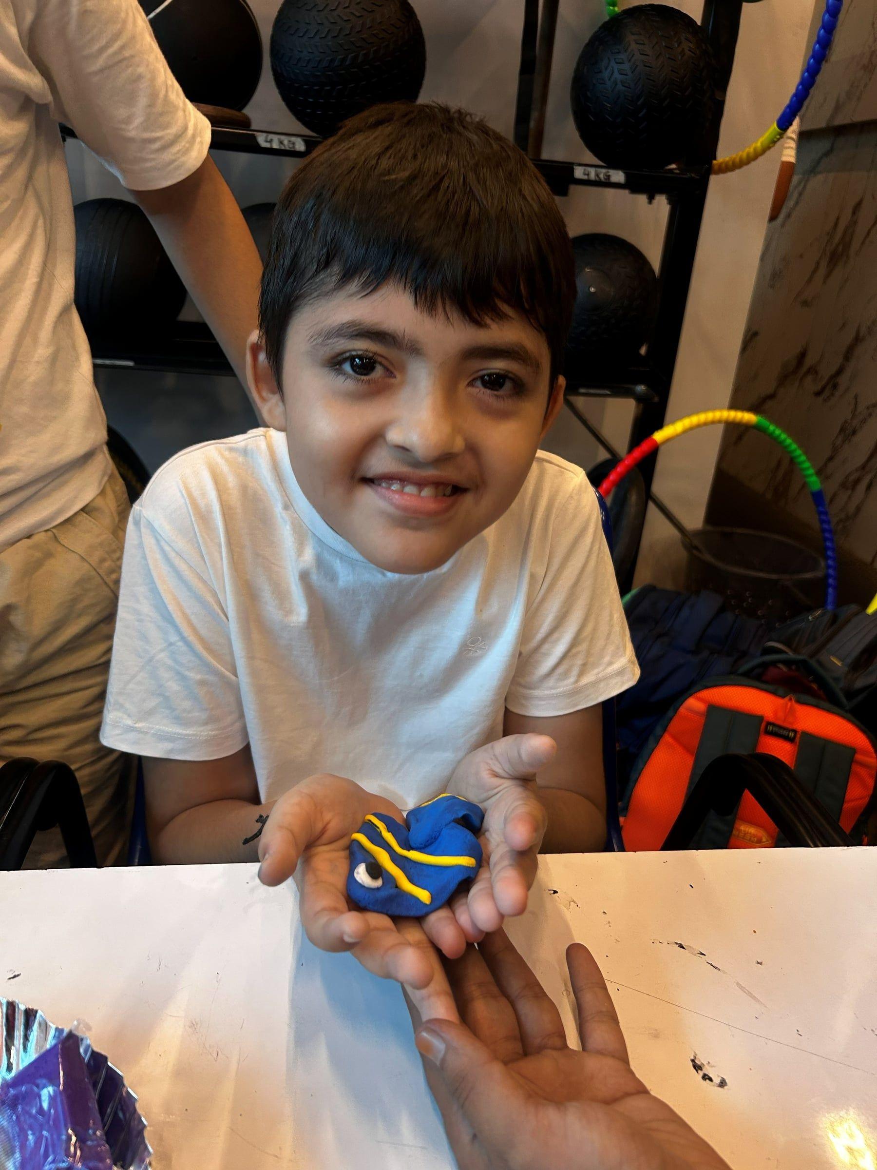 A child holding up the painted rock he decorated