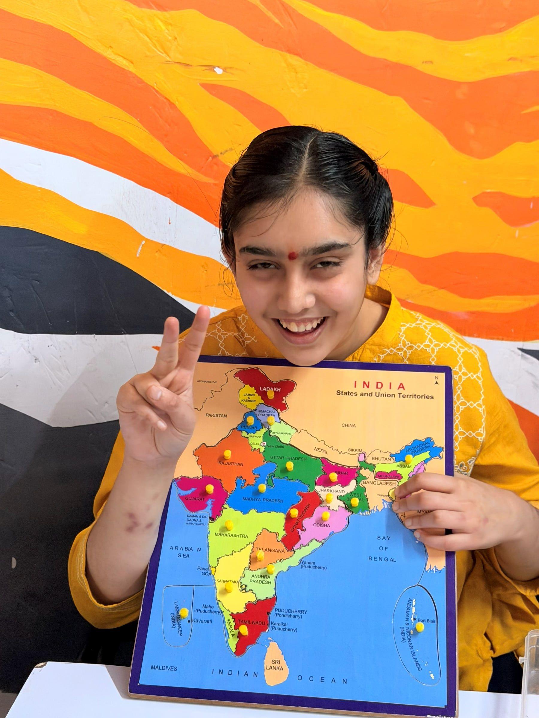 A student presenting a completed map of India puzzle