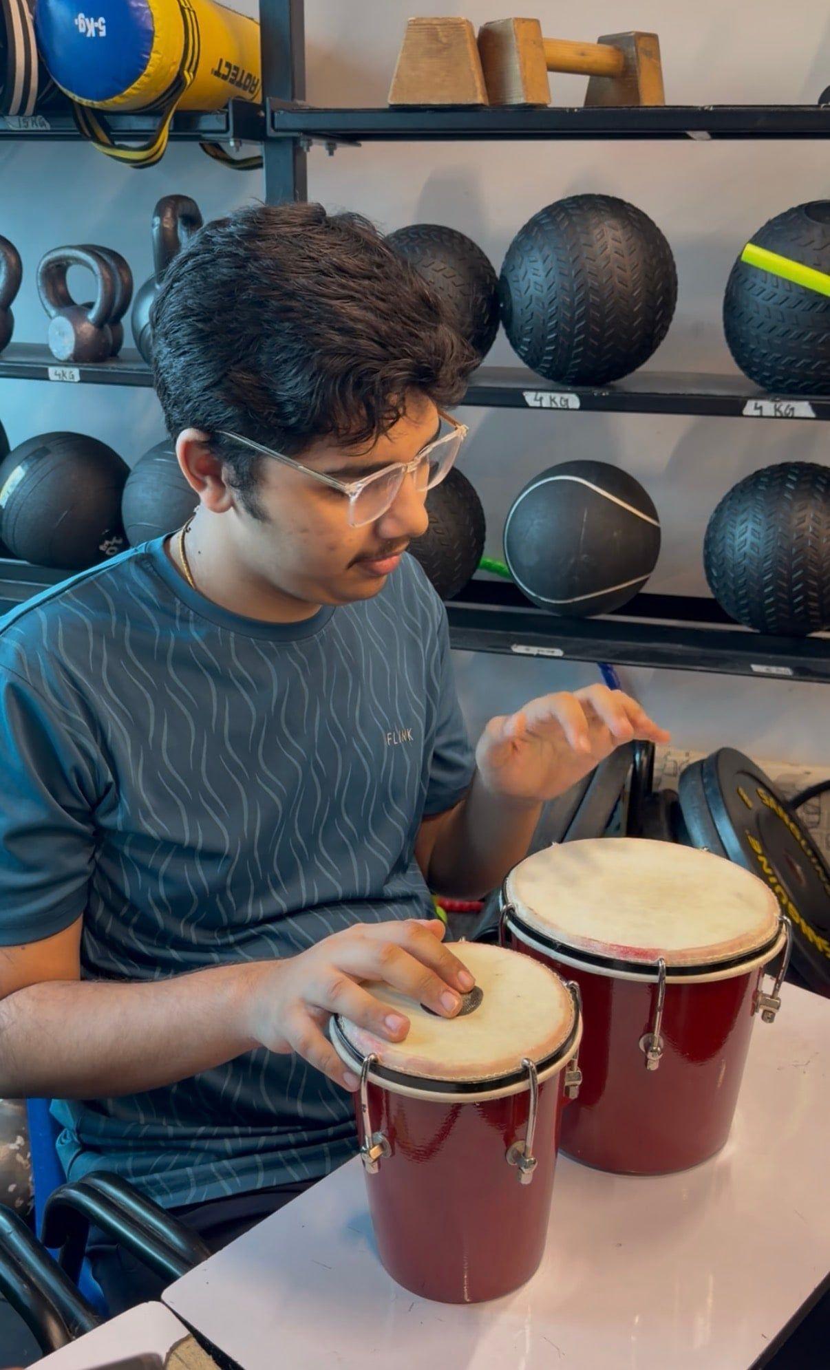 A student keeping rhythm on the bongo drums