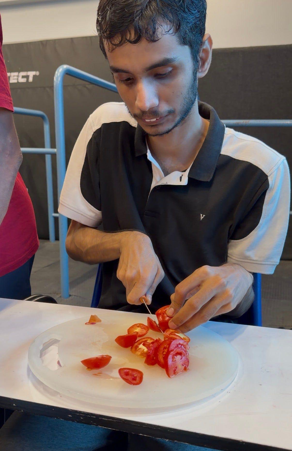 A student chopping vegetables during a cooking session