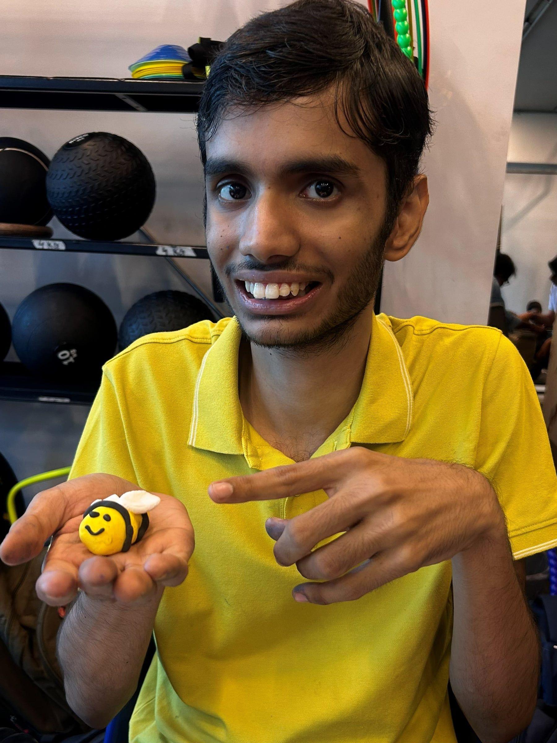 A student showing the bee he painted on a rock