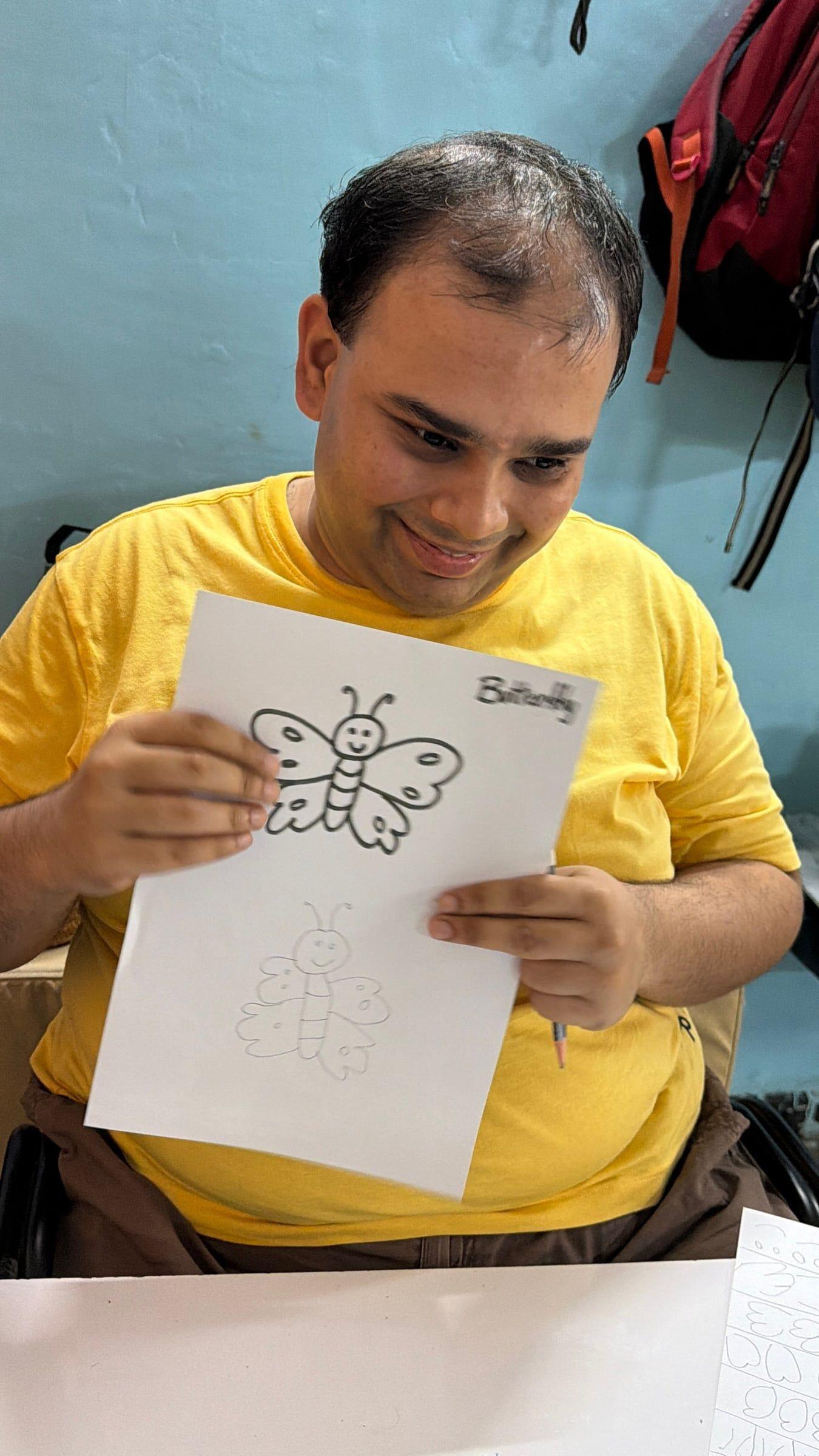 A participant proudly holding up the butterfly they drew